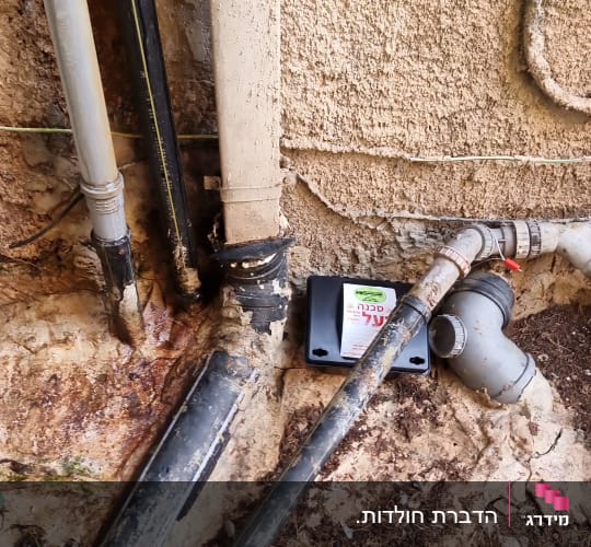 קופסת הדברה ליד צינורות על קיר חיצוני